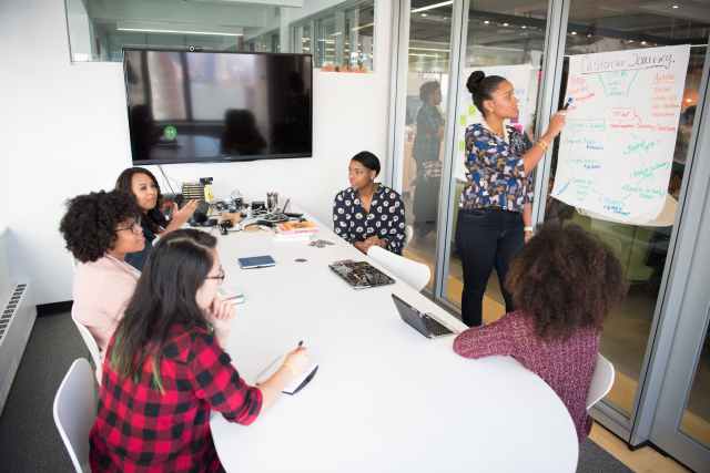 six woman standing and siting inside the room