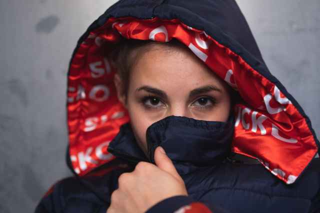 close up photo of woman covering her mouth with her jacket