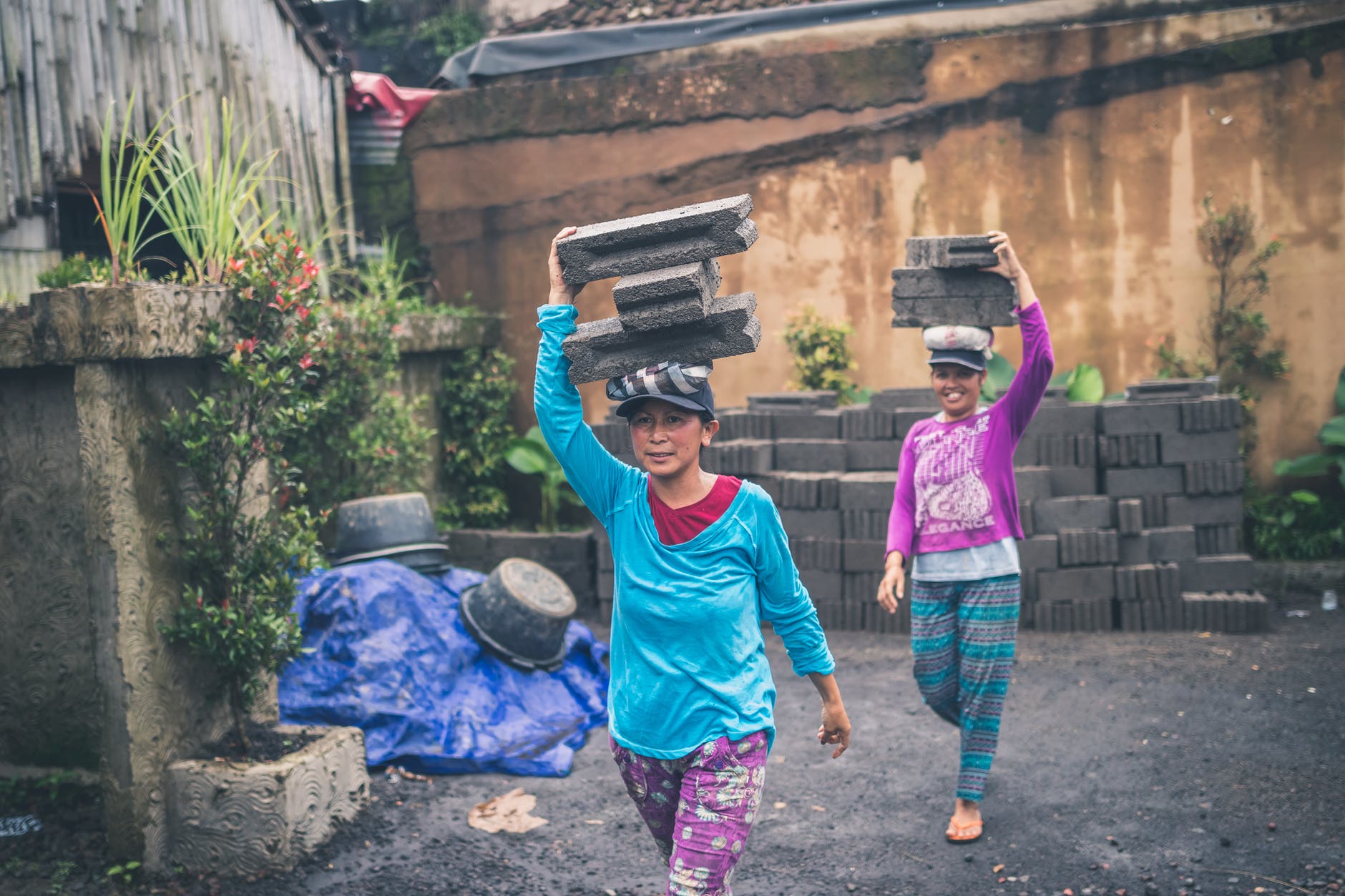 photography of women carrying cinder blocks