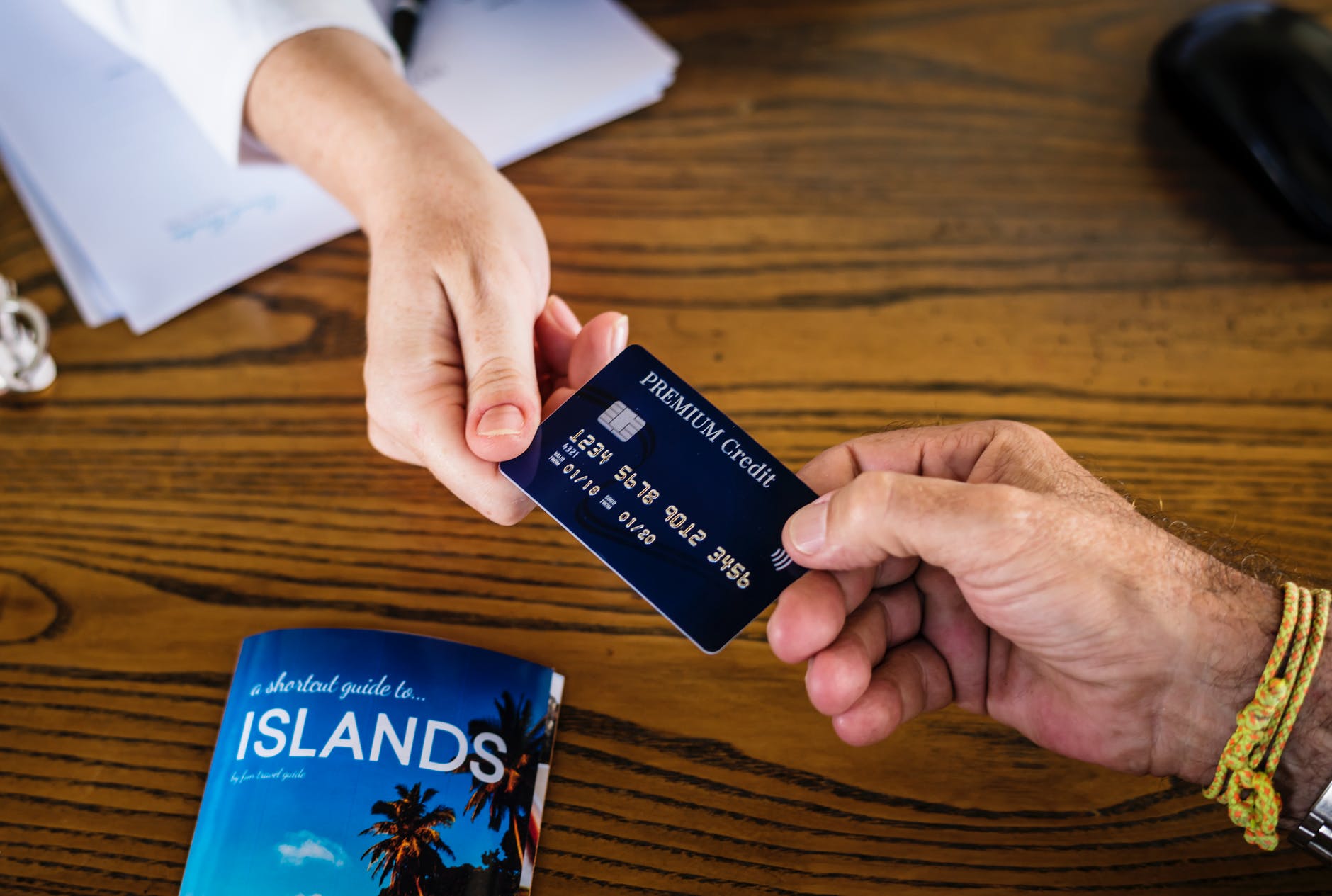 two persons holding premium credit card