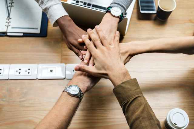 five person holding hands over socket plates