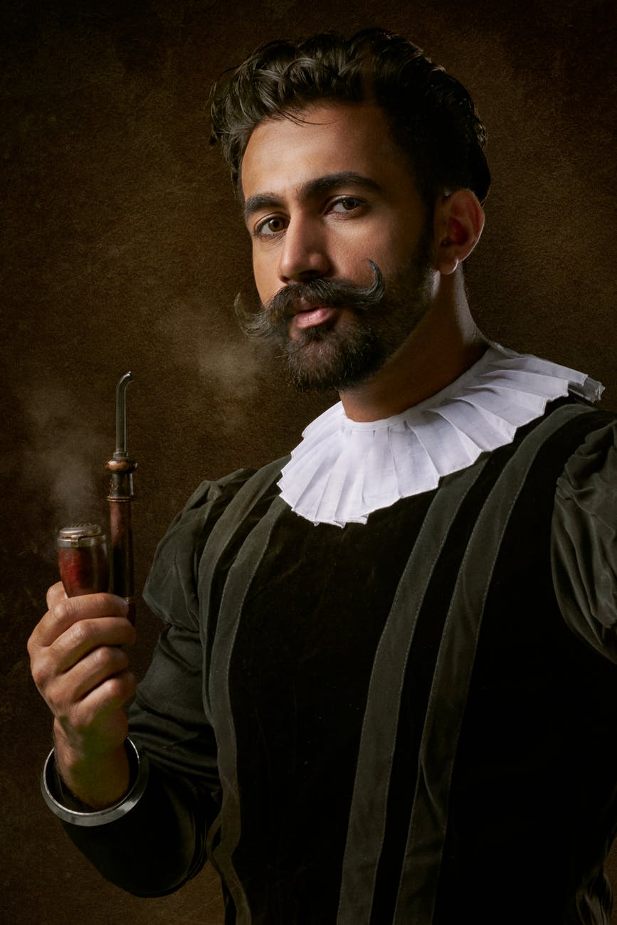 man holding tobacco pipe