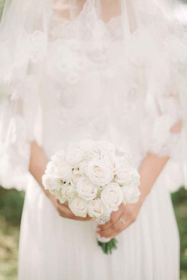 woman wearing white wedding gown while holding bouquet