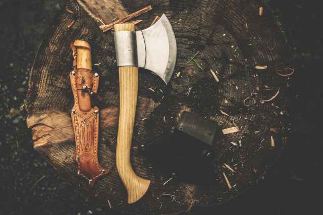 brown wooden axe besides brown leather knife holster