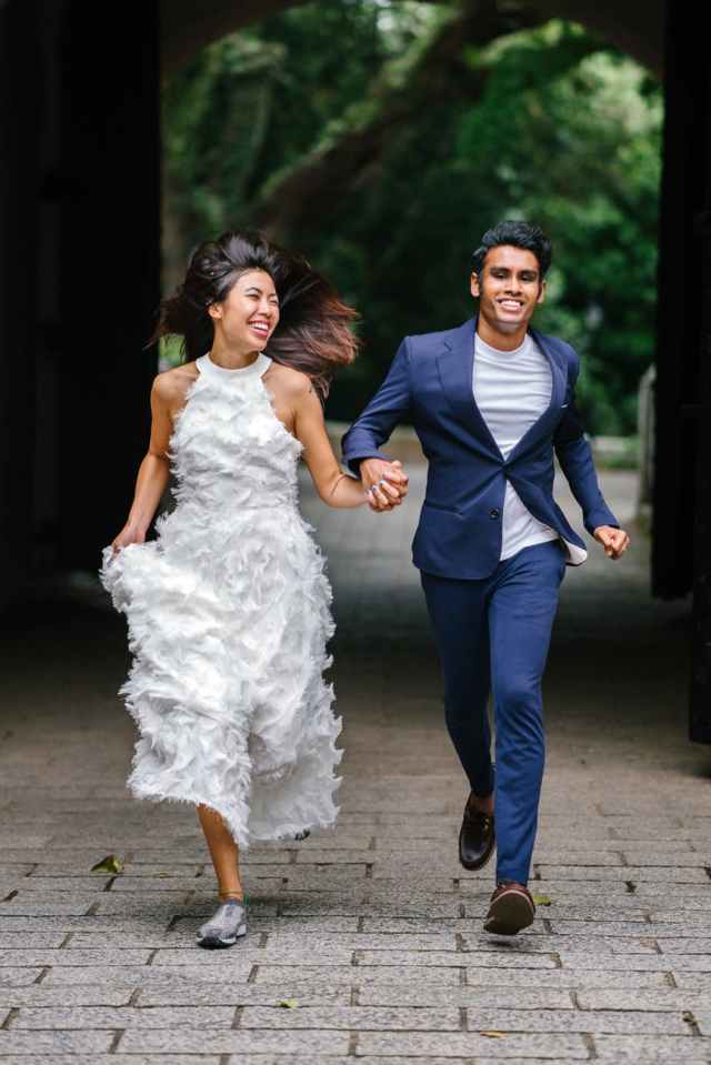 bride and groom running on concrete pathway