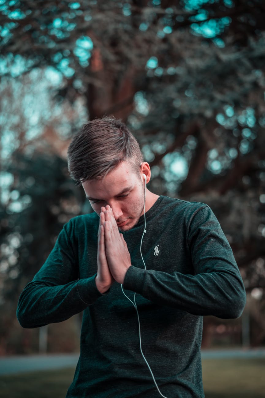 man in green sweater holding his hands