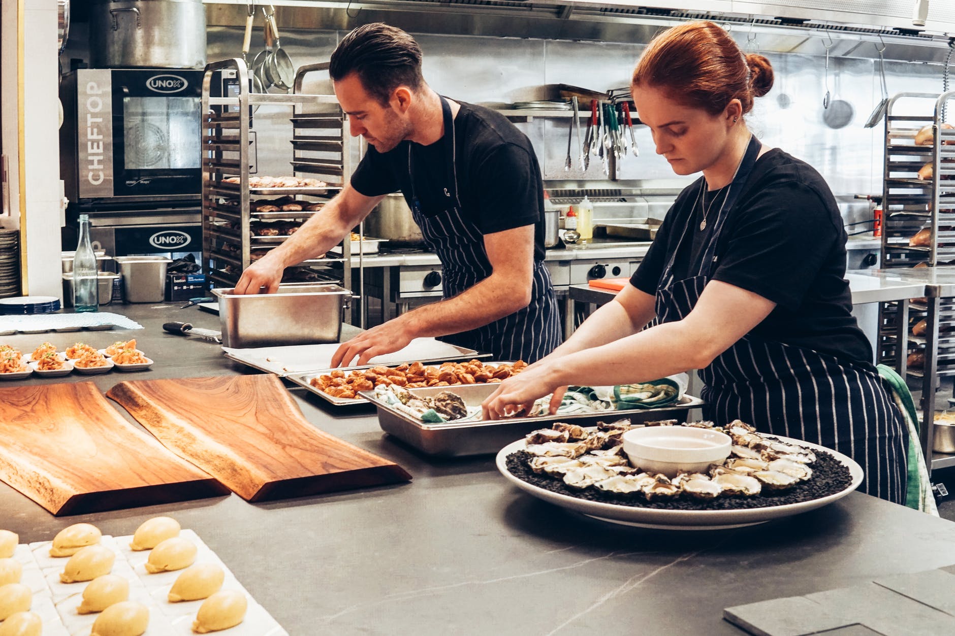 man and woman wearing black and white striped aprons