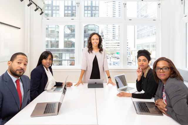 woman standing on the center table with four people on the side