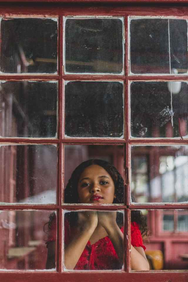 woman in front of red glass window