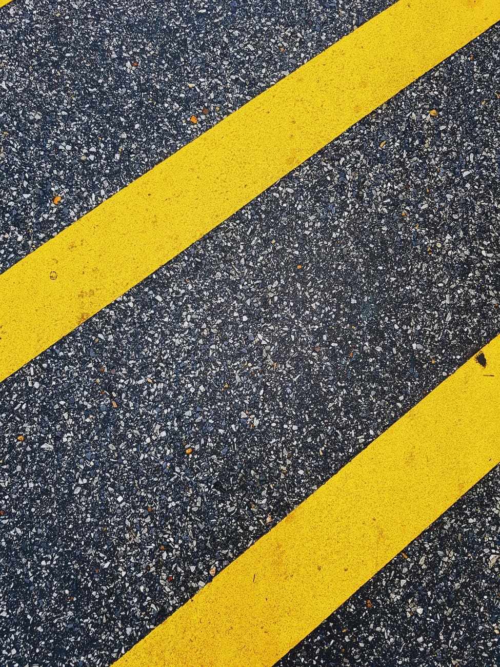 yellow and black lines on gray concrete pavement