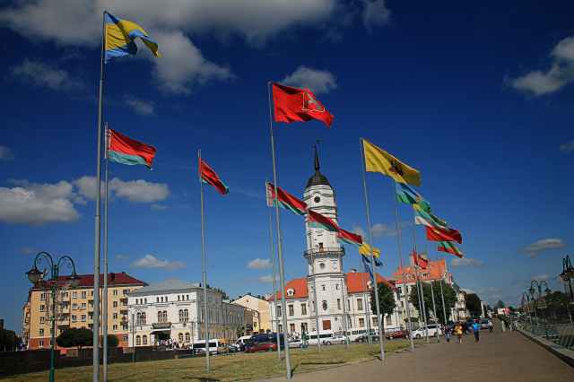 different flags waving on poles at daytime